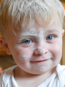 Young boy covered in flour