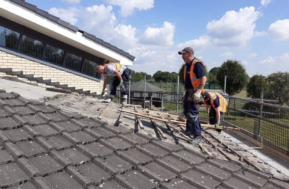 Workers tiling a roof