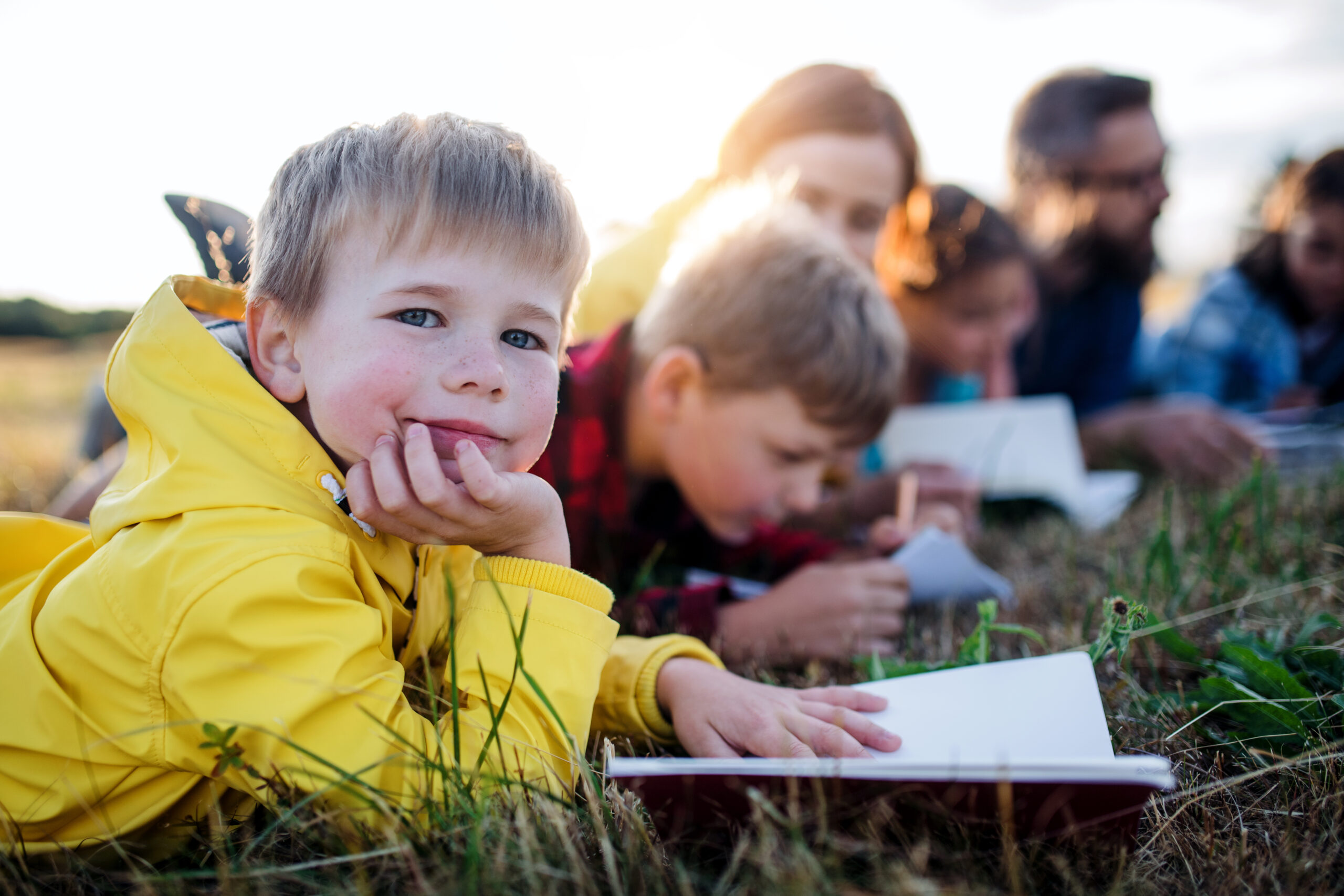 Early years children reading outdoors, field trip in nature