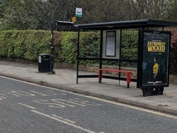 A bus stop with advertising on
