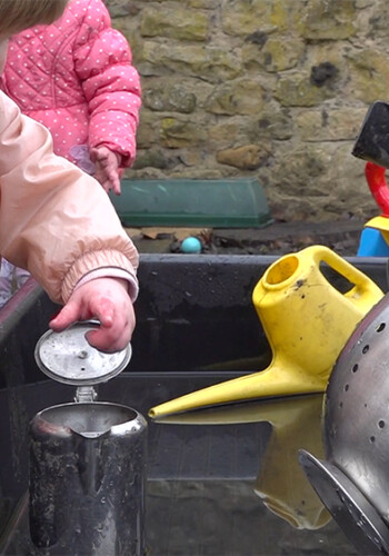 Infant playing at a water table