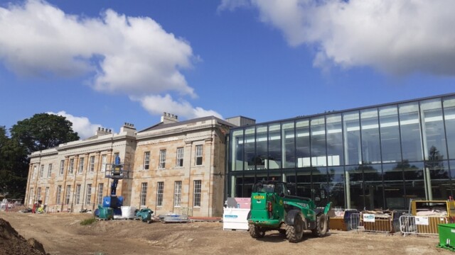 Exterior view of the Mount Oswald Georgian Manor House during construction including some of the building vehicles and skips used on site