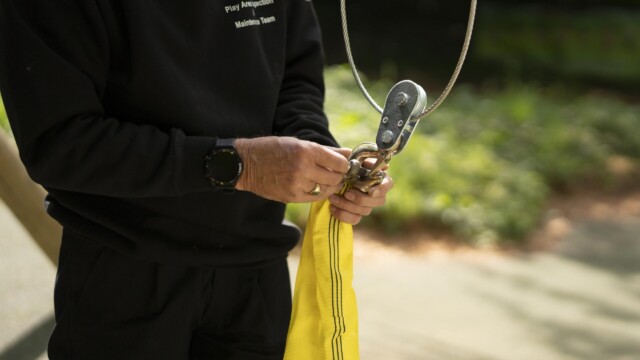 A gentleman putting together a clip on a swing