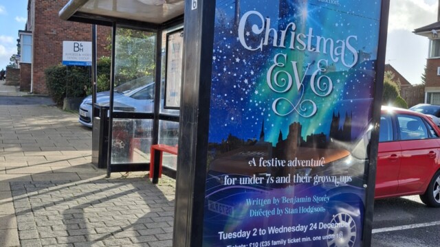 A bus stop with Christmas advertising on
