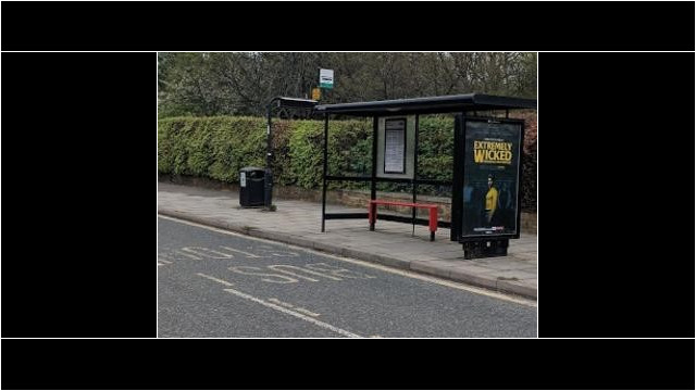 A bus stop with advertising on