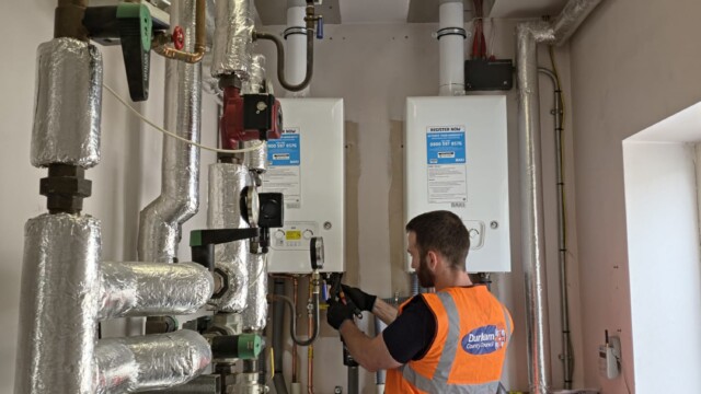 Engineer repairing boiler in annex